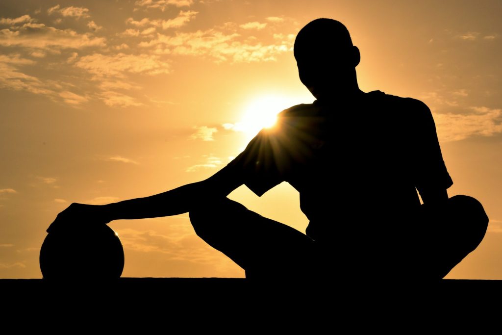 a silhouette of a man holding a basketball ball