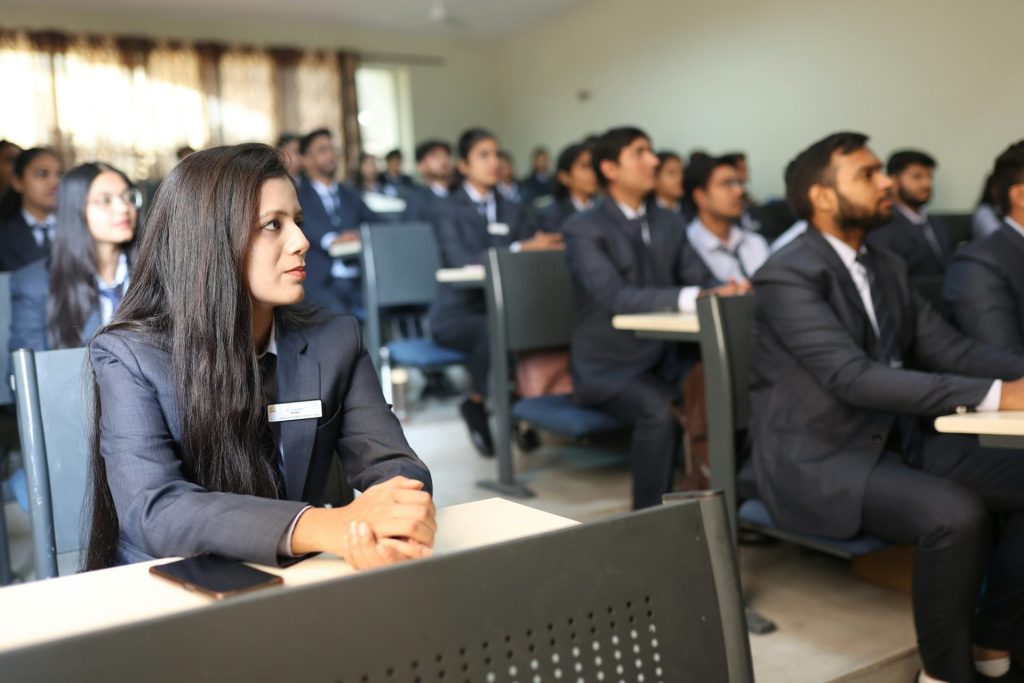Students in uniforms listening attentively in a classroom.