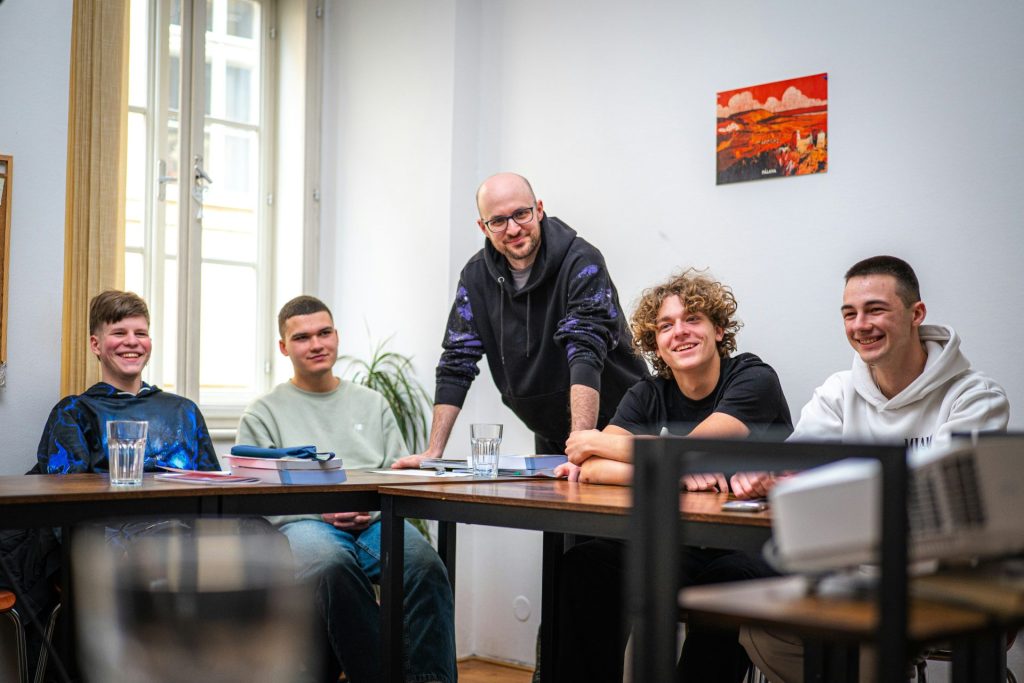 Group of young men and an adult at a table